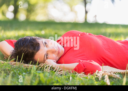 Reife Frau liegend auf dem Rasen Stockfoto