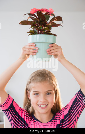 Porträt eines Mädchens (8-9) hält Blumentopf Stockfoto