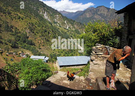 Ein Gurung Mann Reinigung sein Gesicht auf einem Hügel. Stockfoto