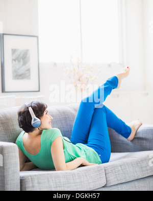 Junge Frau Musikhören zu Hause Stockfoto