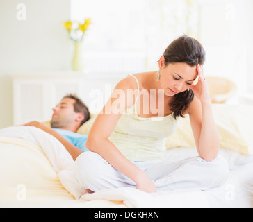 Traurige Frau im Schlafzimmer, Mann schläft Stockfoto