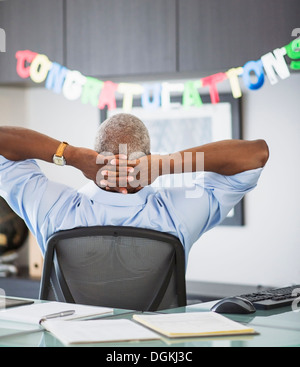 Rückansicht des Menschen im Büro, herzlichen Glückwunsch Zeichen im Hintergrund Stockfoto