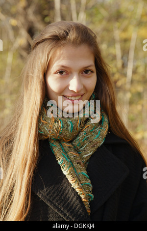 Mädchen im Herbst Park Lächeln schaut in die Kamera Stockfoto