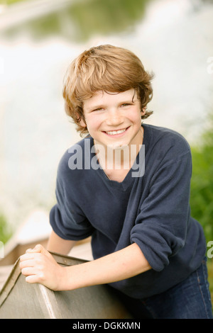 Junge (12-13) posieren mit Boot auf dem Rasen in der Nähe von See Stockfoto