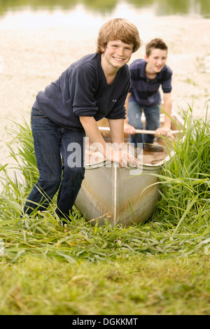 USA, New Jersey, alten Docht, zwei jungen (12-13) posieren mit Boot auf dem Rasen in der Nähe von See Stockfoto