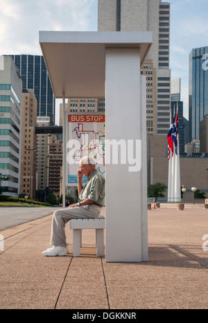 USA, Texas, Dallas, Senior Mann sitzt an der Bushaltestelle und Handy Stockfoto