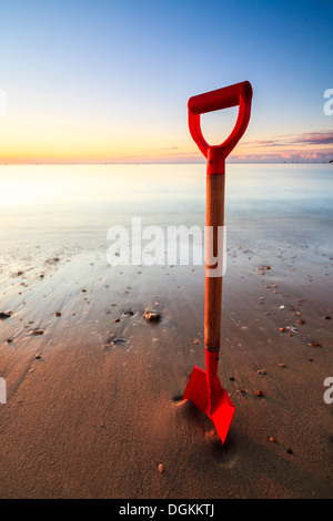 Spaten Sie in den Sand am Strand von Swanage an einem sonnigen Morgen. Stockfoto