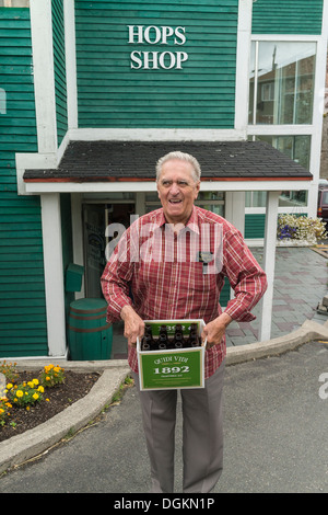 Ein älterer Erwachsener Mann hält eine 12-Pack der leere Bierflaschen, die er wieder in die Quidi Vidi Brauerei in St. John's, Neufundland. Stockfoto