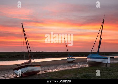 Drei Boote aus Holz, wartet auf die Rückkehr von Ebbe und Flut bei Sonnenuntergang. Stockfoto