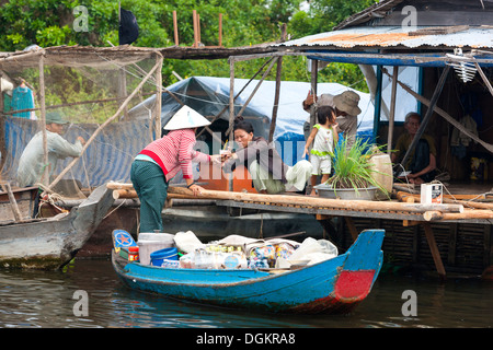 Eine Frau verkauft Kaffee aus dem Boot in das schwimmende Dorf auf dem Tonle Sap See. Stockfoto