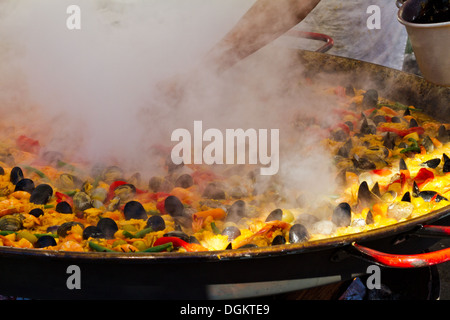 Kochen Sie, tendenziell eine große Pfanne Paella Kochen über einem Holzfeuer auf einem Meeresfrüchte-Festival in Santa Barbara, Kalifornien Stockfoto