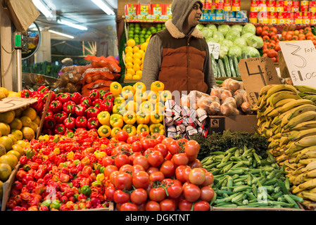 Ein Gemüsehändler Köpfen einen bunten Stand in Brixton Market. Stockfoto