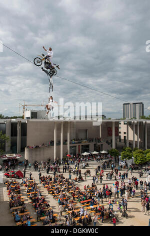 Museum Mile Festival, Hochseil-Artist Falko Traber auf einem Motorrad auf dem Hochseil, Publikum unten, Bonn Stockfoto