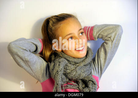 Lächelndes Mädchen, 10 Jahre alt, halten ihre Arme hinter ihrem Kopf Stockfoto