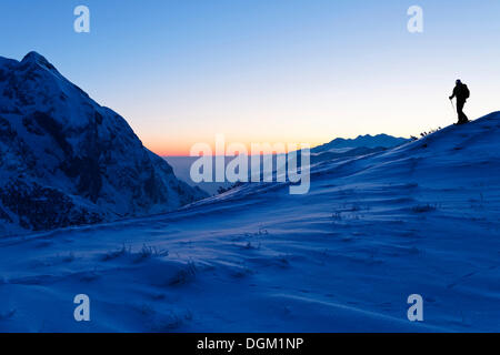 Mann auf einer Schneeschuhtour auf der Torrener Joch Pass, Blick auf die Berge des Grimming, Krippenstein und plassen Stockfoto