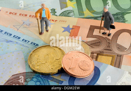 Rentner-Figuren, Euro-Münzen, Banknoten, symbolisches Bild für Renten Stockfoto