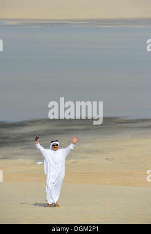 Qatari in traditioneller Kleidung mit Gutra, vor Khor Al Udeid Strand, Khor El Deid, Binnenmeer, Wüste Wunder von Katar Stockfoto