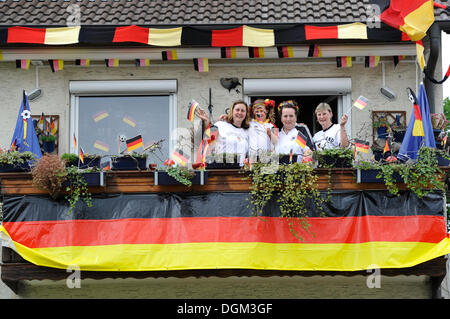 Fans der deutschen Nationalmannschaft im deutschen Team-Trikots und mit Nationalflaggen vor einem geschmückten Haus, Stuttgart Stockfoto