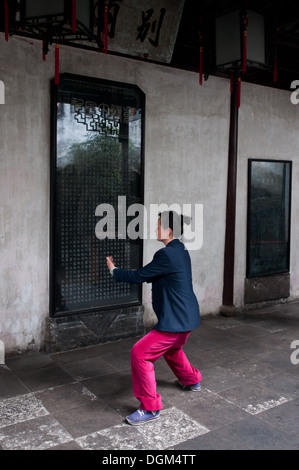 Frau üben Taijiquan (Tai Chi) im YuGarten (Garten der Glückseligkeit
