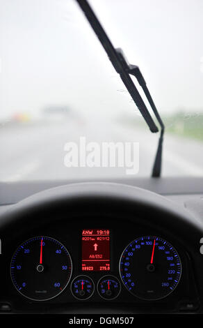 Schlechte Sicht bei Regen, Autobahn, beleuchtete Tachometer mit Navigations-Display, fahren VW Golf Stockfoto