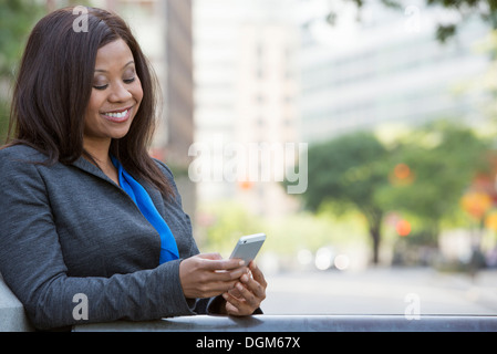 Sommer. Eine Frau in einem grauen Anzug mit einem leuchtend blauen Shirt. Stockfoto