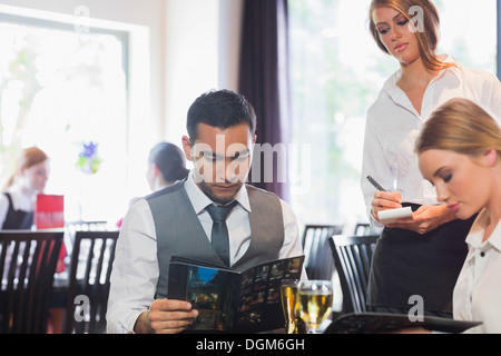 Gut aussehend Geschäftsmann Lesen der Speisekarte Stockfoto