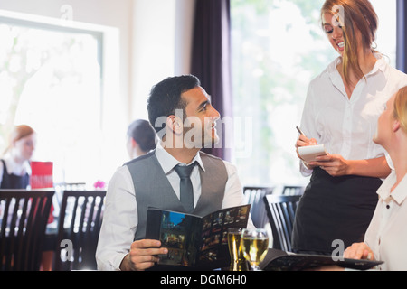 Gut aussehend Geschäftsmann Essen von Kellnerin bestellen Stockfoto