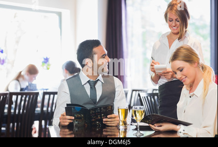 Geschäftsleute, die Speisekarte lesen und bestellen Stockfoto