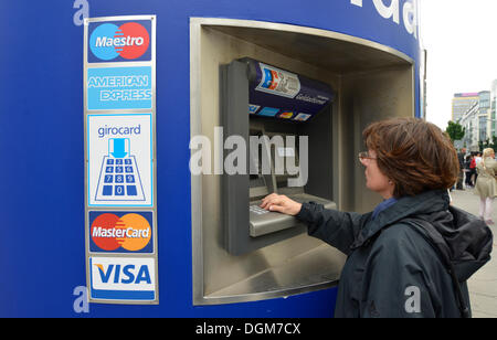 Frau Betrieb einen EC-Geldautomaten für VISA, Maestro, American Express und Girocard Bank Karten, Berlin, Berlin, Deutschland Stockfoto