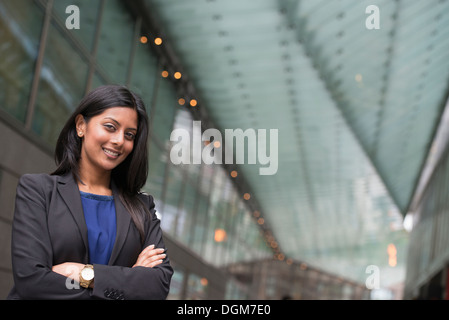 Business-Leute. Eine junge Frau in einem blauen Kleid und grauen Jacke. Stockfoto