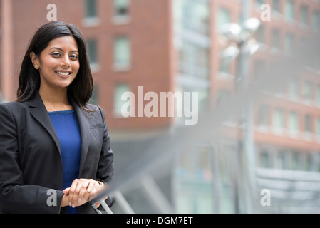 Business-Leute. Eine junge Frau in einem blauen Kleid und grauen Jacke. Stockfoto