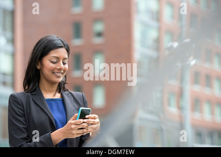 Business-Leute. Eine junge Frau in einem blauen Kleid und grauen Jacke. Stockfoto