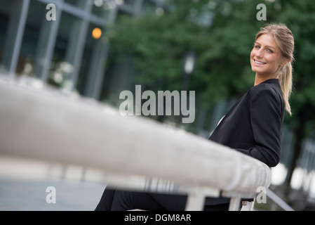 Eine junge blonde Frau auf einer Straße in New York City. Trug eine schwarze Jacke. Stockfoto