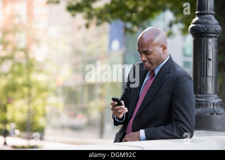 Business-Leute. Ein Mann in einem Anzug überprüft sein Telefon. Stockfoto