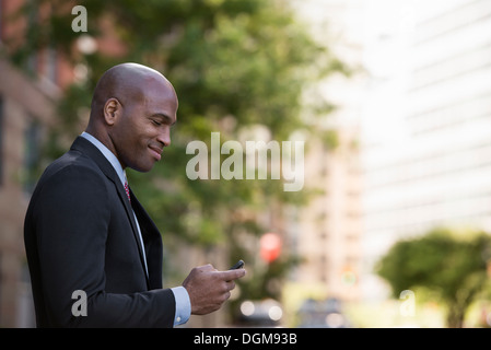 Business-Leute. Ein Mann in einem Anzug überprüft sein Telefon. Stockfoto