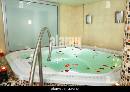 Badewanne mit Whirlpool mit Blütenblättern von Rosen Stockfoto
