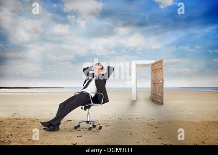 Geschäftsmann auf Drehstuhl am Strand Stockfoto