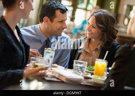 Business-Leute. Vier Personen, ein Mann und drei Frauen an einem Tisch sitzen. Stockfoto