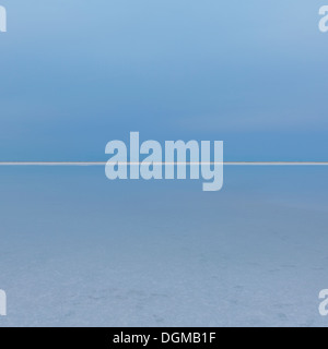 Flaches Wasser Salzsee von Bonneville in der Abenddämmerung. Das Land treffen den Himmel am Horizont und eine weiße Linie von Salzkristallen. Stockfoto