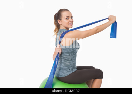 Ziemlich Fit Frau dehnen ihr Arme mit einem Widerstand band Stockfoto