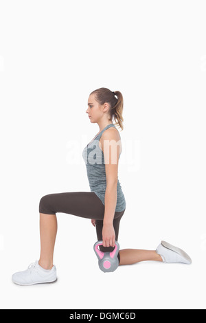 Blonde Frau beim Longieren mit Kettle Bell training Stockfoto