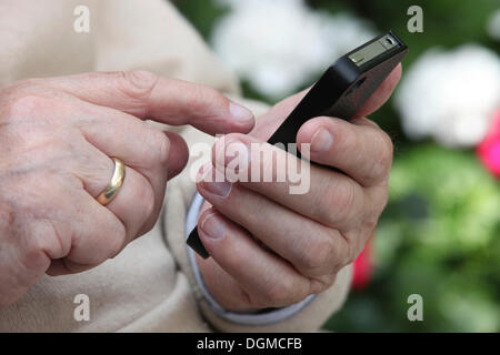Älterer Mann mit einem Smartphone in der hand Stockfoto