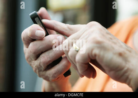 Ältere Frau mit einem Smartphone in der hand Stockfoto