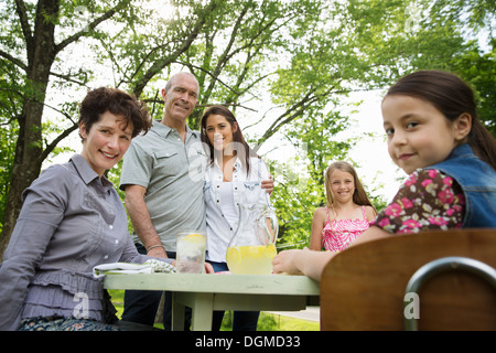 Ein Sommer-Familientreffen auf einem Bauernhof. Eine Familiengruppe, Eltern und Kinder. Frische Limonade zu machen. Stockfoto