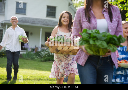 Familienfest. Eltern und Kinder, die Blumen, frisch gepflückten Gemüse und Obst. Vorbereitung für eine Party. Stockfoto