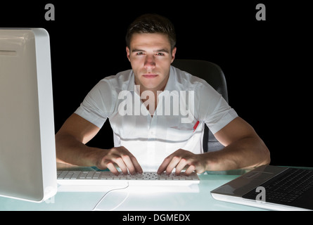 Gut aussehend stirnrunzelnd Computeringenieur arbeitet in der Nacht Stockfoto