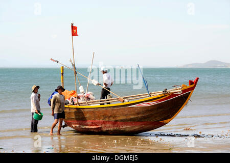 Fischer und ein Fischerboot am Strand von Mui Ne auf das Südchinesische Meer, Süd-Vietnam, Südostasien Stockfoto