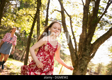 Eine Frau und ein junges Mädchen, die entlang durch die Bäume. Stockfoto