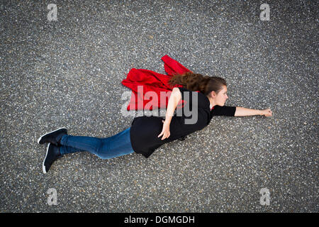 Junge Frau erscheint in Superman oder Supergirl Standpunkt von oben fliegen Stockfoto