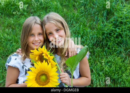 Zwillingsmädchen, 9 mit Sonnenblumen Stockfoto